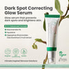 AXIS-Y Dark Spot Correcting Glow Serum product tube displayed with plant background. Text highlights benefits: glow serum that prevents dark spots and brightens skin. Key ingredients include Niacinamide 5%, Squalane, and Sea Buckthorn Fruit Extract. Features icons for Brighten, Skin Conditioning, and Soothe. Vegan and cruelty-free skincare solution.